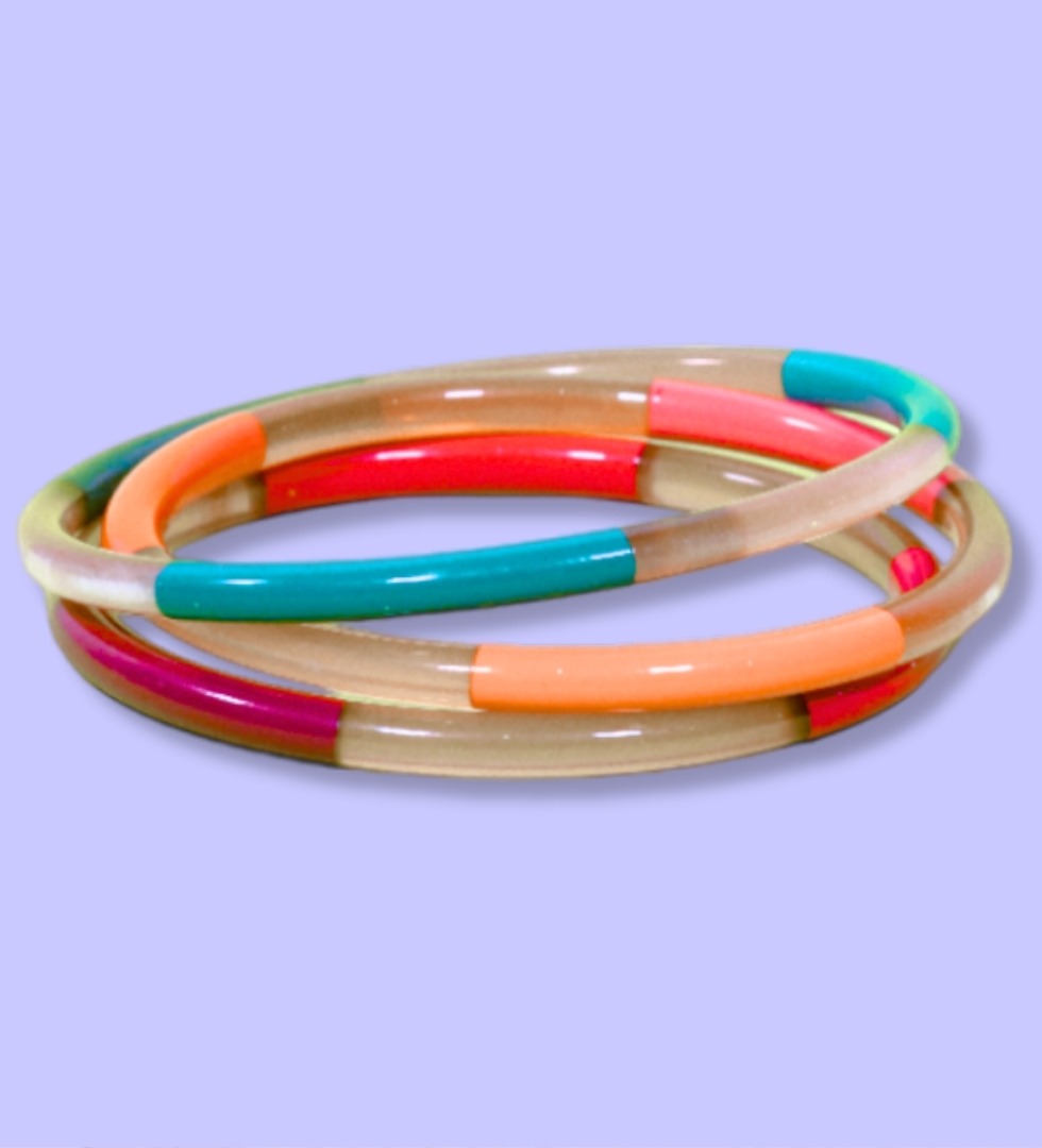 Jonc 5mm colorés mix Jonc en métal de 5 mm d’épaisseur avec un mélange de couleurs vives : rouge, turquoise, orange et beige, présenté sur fond violet.