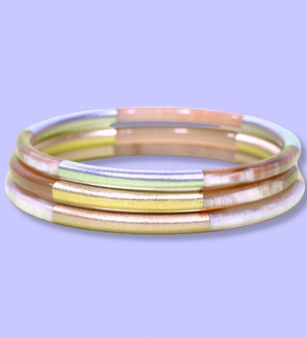Jonc en métal de 5 mm d’épaisseur avec un mélange de couleurs métalliques : argent, or, et cuivre, présenté sur fond violet.